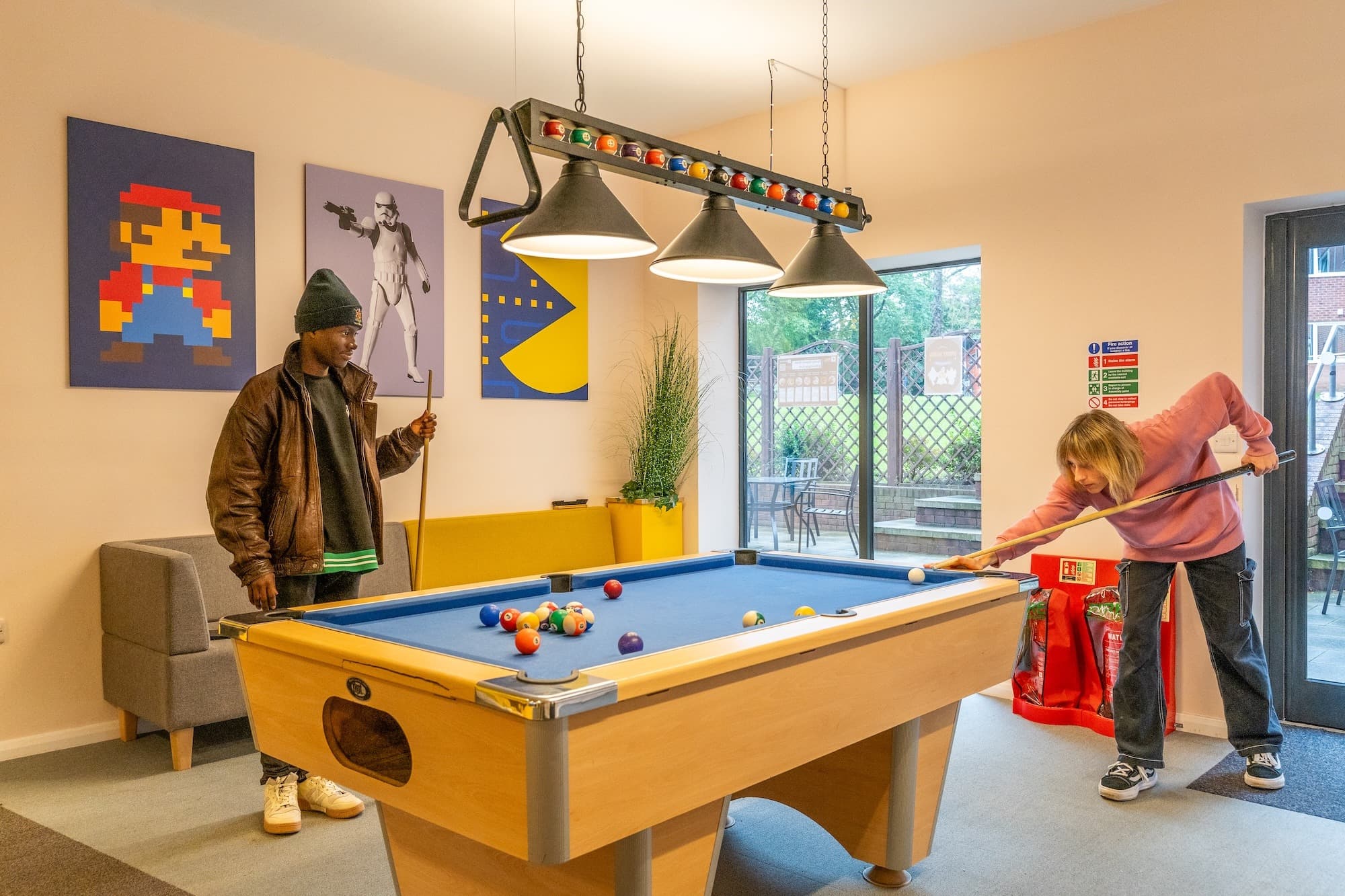 Two students playing pool in a social space